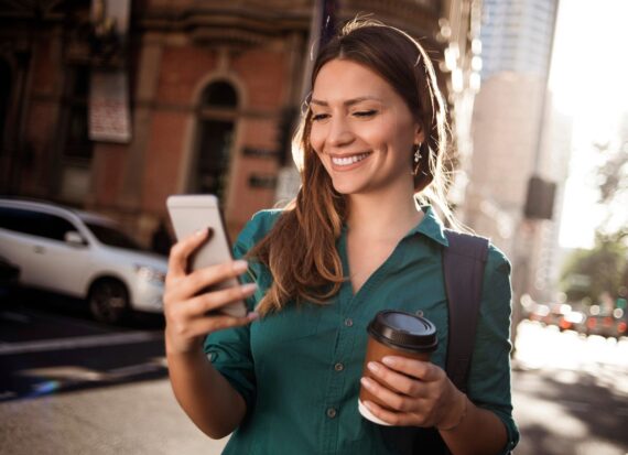 Woman on a metropolitan street looking at her phone while walking