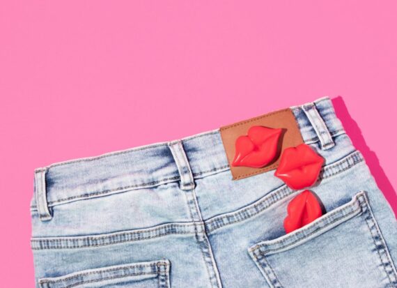 The Back Of A Pair Of Light Wash Denim Jeans With Plastic Lips Coming Out Of The Right Back Pocket The Back Of A Pair Of Light Wash Denim Jeans With Plastic Lips Coming Out Of The Right Back Pocket
