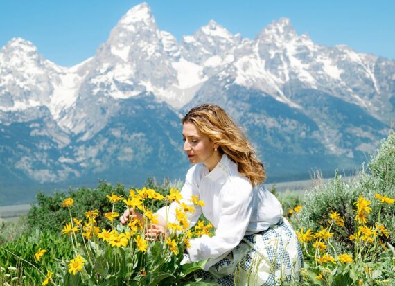 Woman Collecting Yellow Flowers In A Field In Jackson Hole, WY
