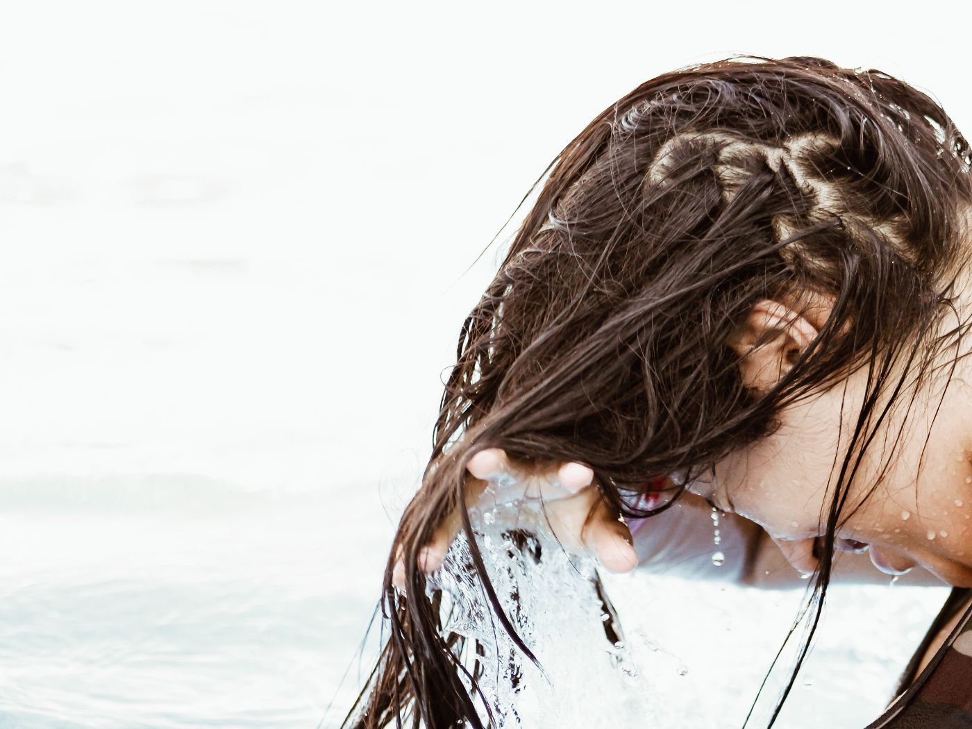 Woman rinsing her hair and scalp in the ocean