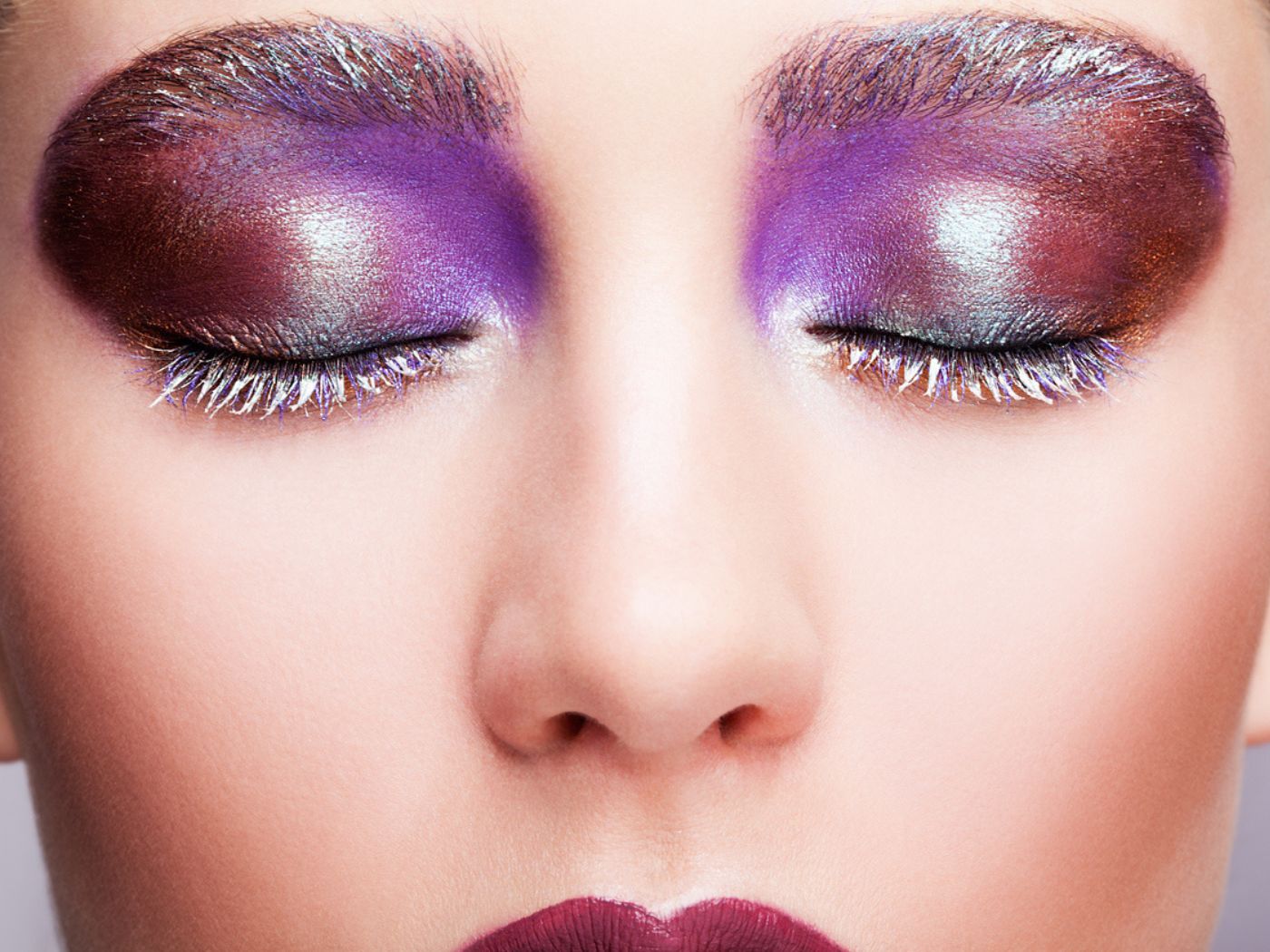Closed eyes with dramatic purple and dark red eyeshadow