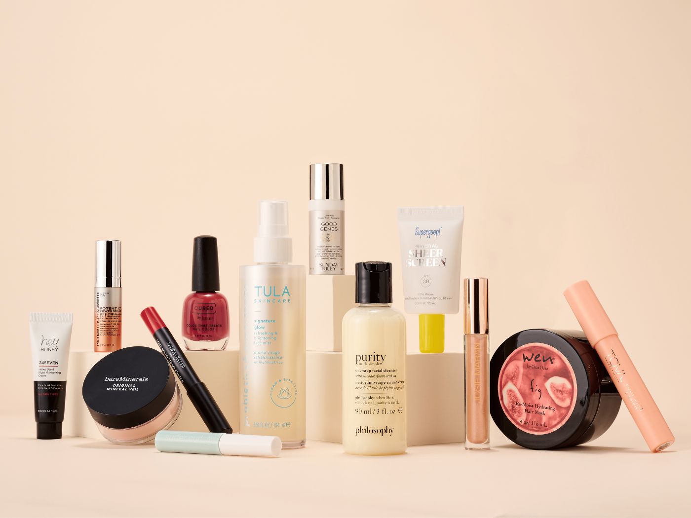 Display of various beauty products on a neutral background