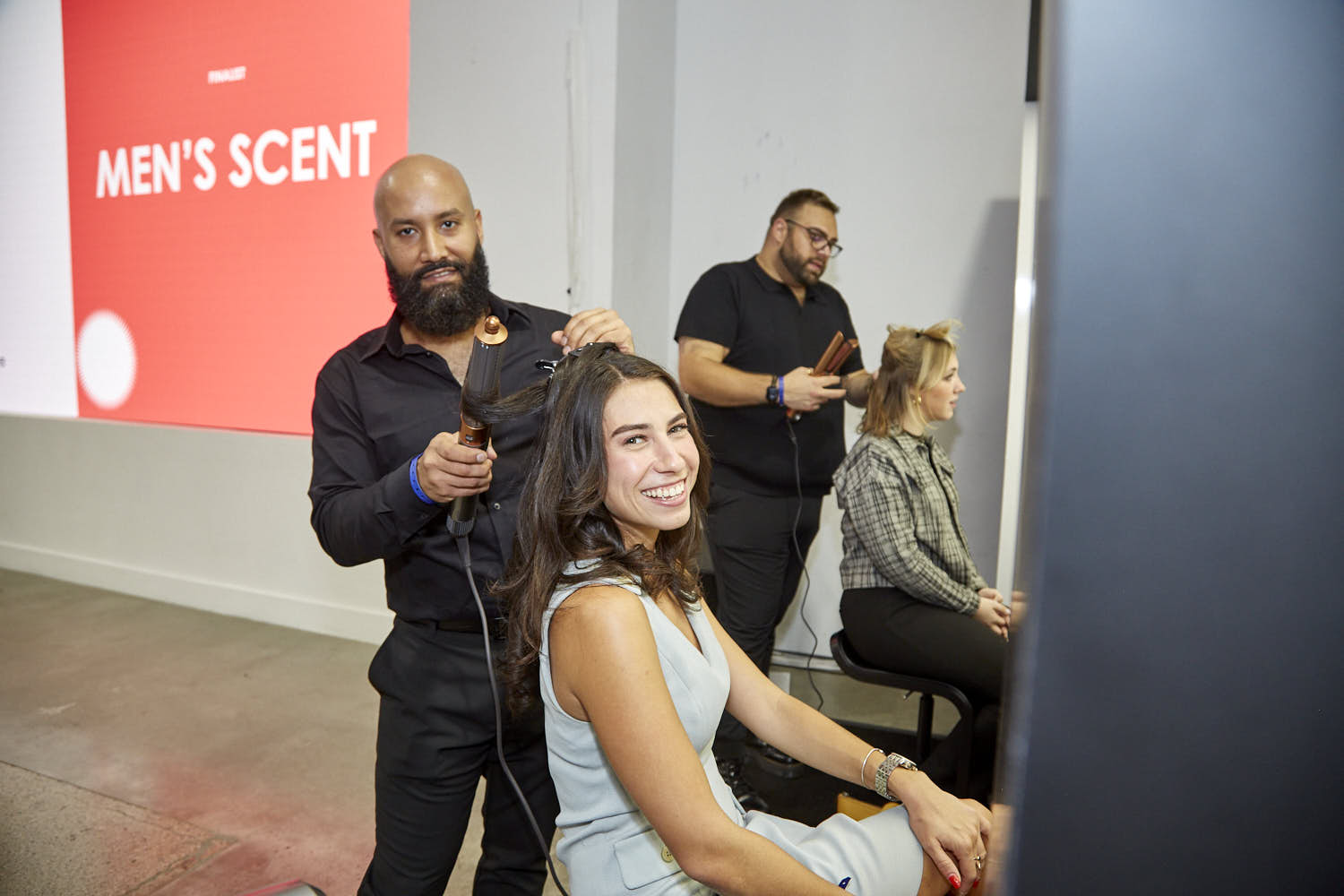 Male hairstylist working on a woman's hair.