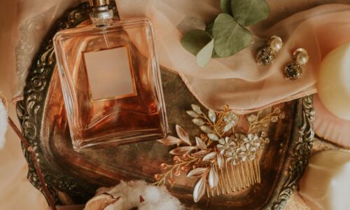Perfume bottle nestled among tulle and jewelry and eucalyptus