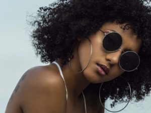 Black woman with curly hair and sunglasses on