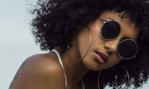 Black woman with curly hair and sunglasses on