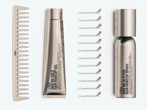A gold hair comb, some golden hair grips, one gold tube and a gold can.
