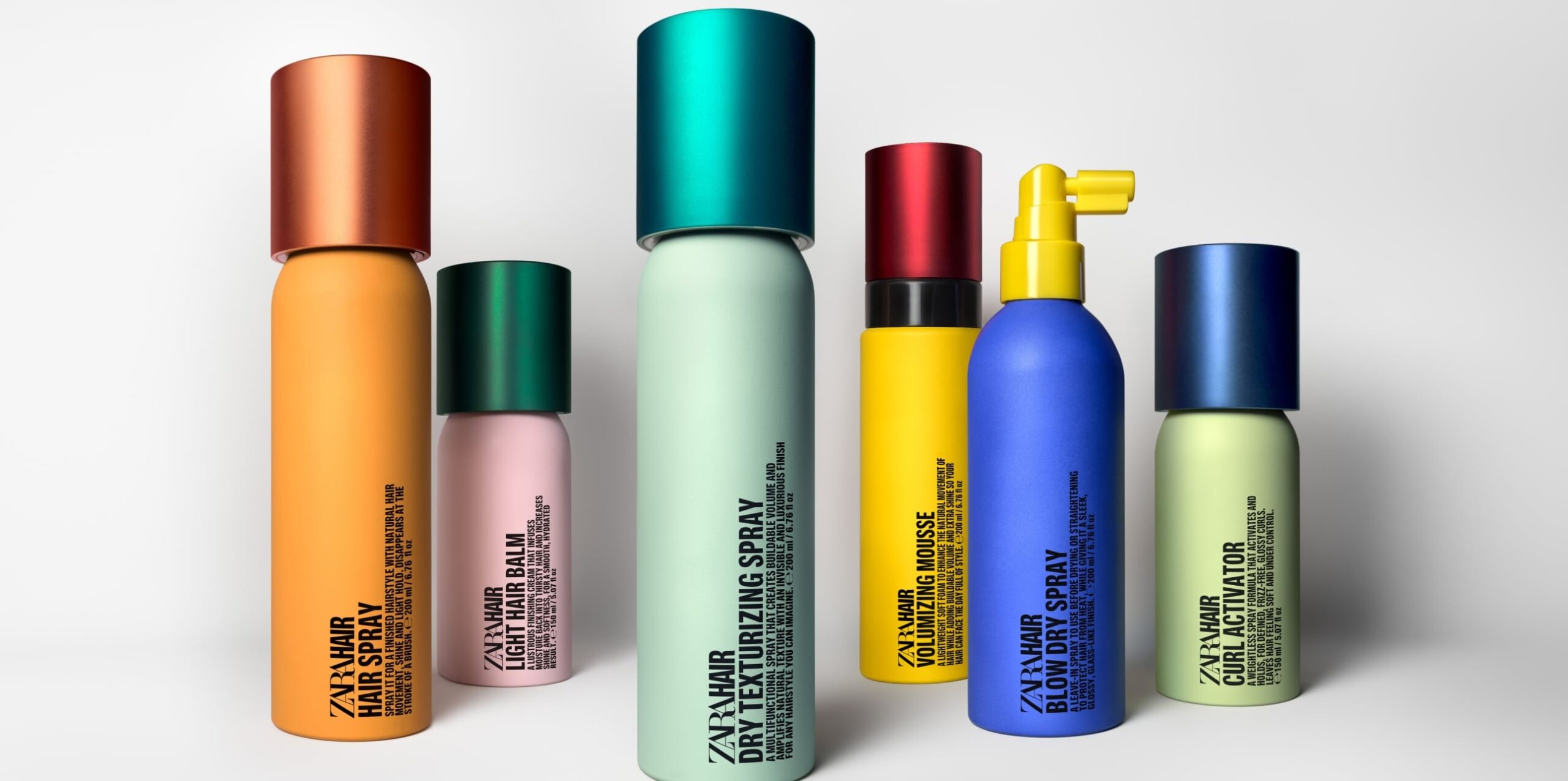 A collection of cans in different sizes of brightly coloured haircare products.