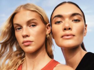 Two models wearing bronzing make-up.