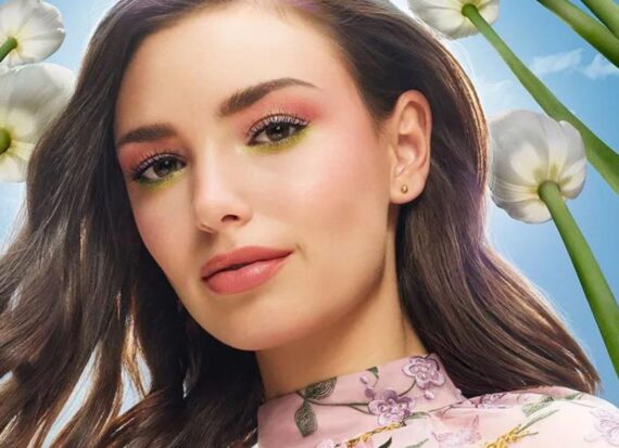 Model in pink floral top with multi-coloured eyeshadow.