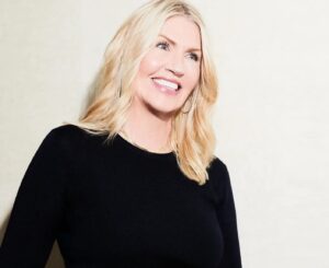 Sarah Creal wearing a black sweater, laughing.