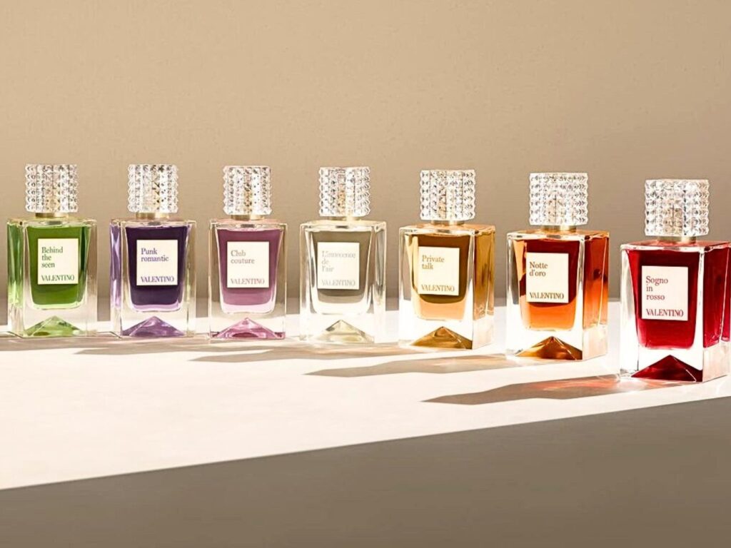 A line up of different coloured Valentino perfumes in glass, decanter-style bottles.
