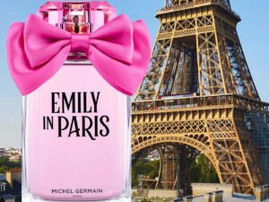 Emily In Paris perfume bottle. with a large pink bow, in front of the Eiffel Tower