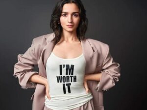 Alia Bhatt wears a pink trouser suit and black and white t-shirt with the slogan "I'M WORTH IT".