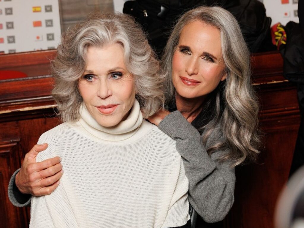 Andie Macdowell seated with her arm around Jane Fonda's shoulders