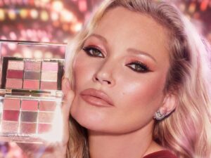Kate Moss wearing glittering makeup, holding a makeup palette