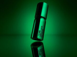 A bright green can of ZARA hair perfume, ZARA HAIR logo in black, against a green backdrop and lighting