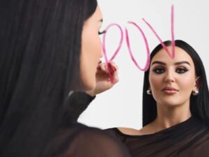 Mikayla Nogueira draws POV on a mirror in pink lipstick