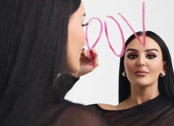 Mikayla Nogueira draws POV on a mirror in pink lipstick