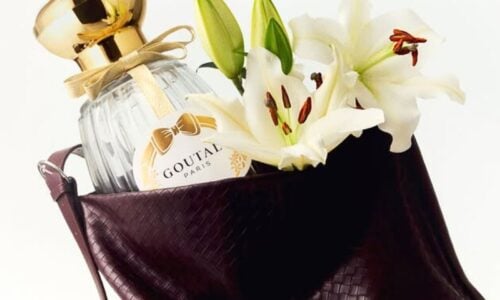 goutalparis Brown leather toe bag open with a bottle of Goutal Paris perfume inside and bunch of Lillies in full bloom