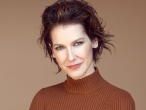 Kristen Arnett wearing a copper coloured rollneck sweater smiling