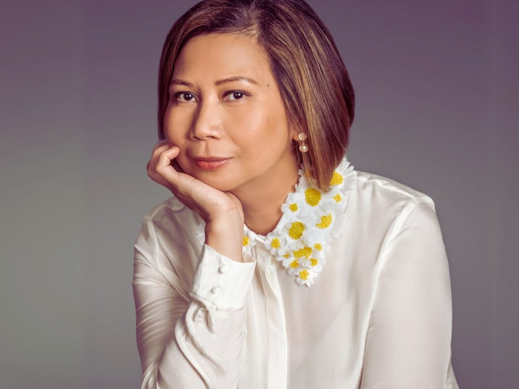 Liza Rapay, wearing a white blouse with daisy detail on the collar
