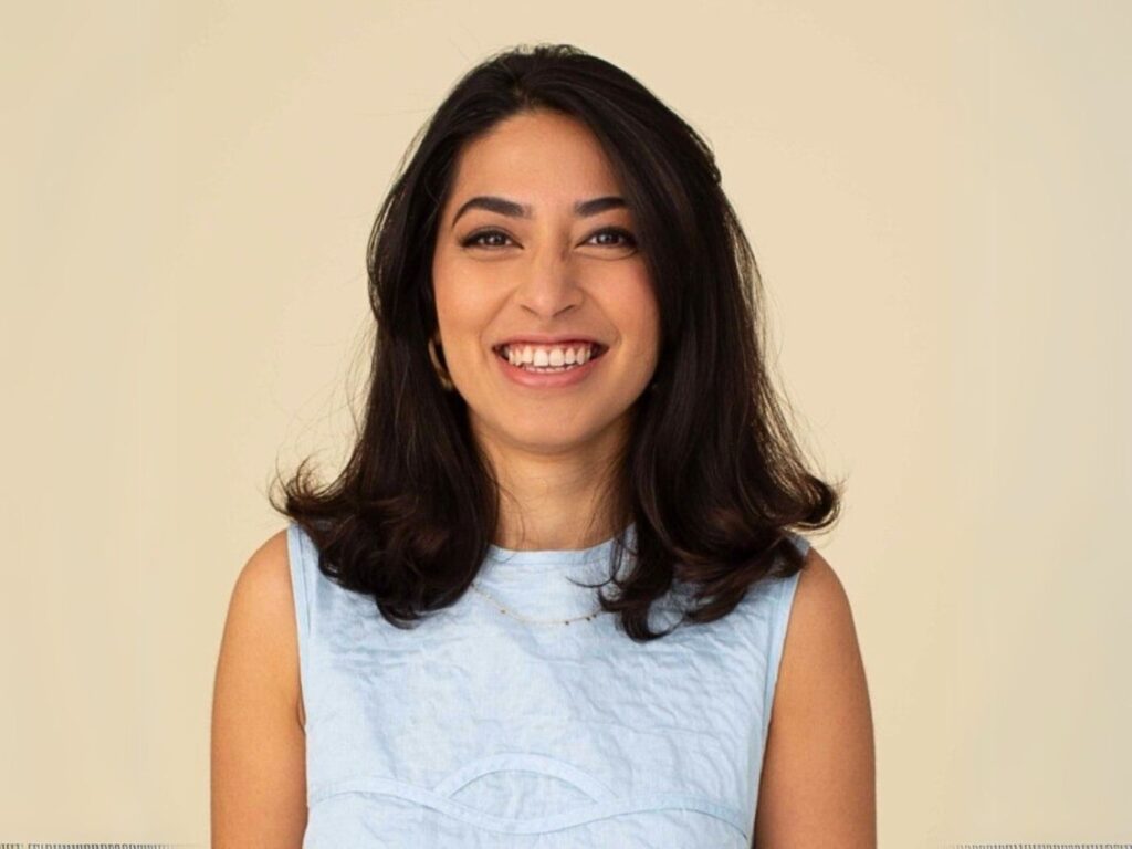 Insiya Jafferjee smiling, wearing a pale blue shift dress