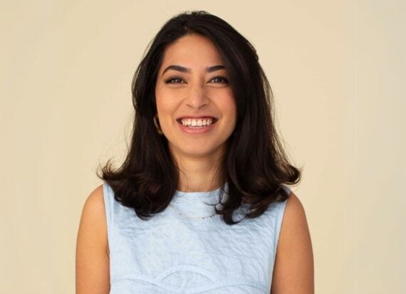 Insiya Jafferjee smiling, wearing a pale blue shift dress
