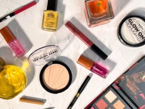 A range of Avon makeup and perfume laid out on a white counter