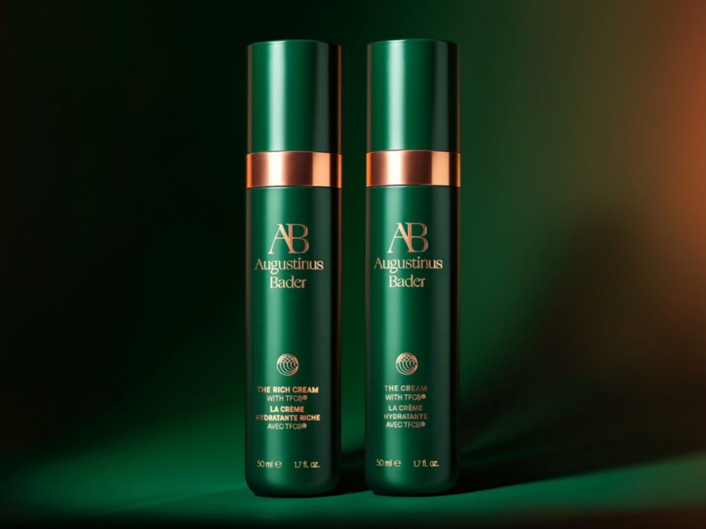 Two Augustinus Bader bottles in metallic green and gold, rather than the usual trademark deep blue