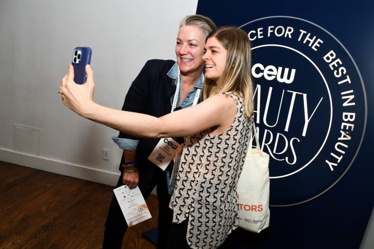 Guests taking a photo at the CEW Beauty Awards wall